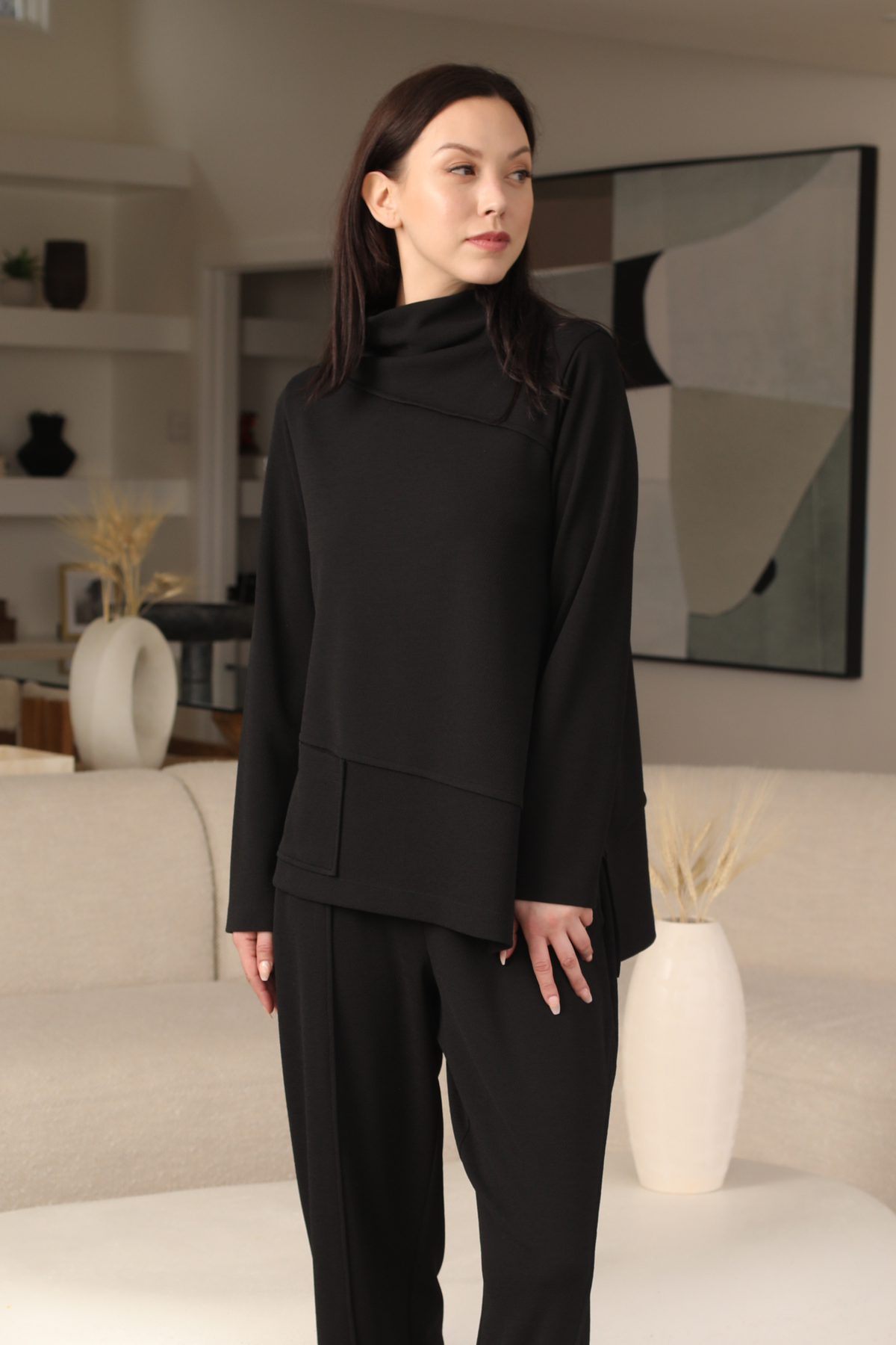 Woman wearing a black outfit in a modern living room setting