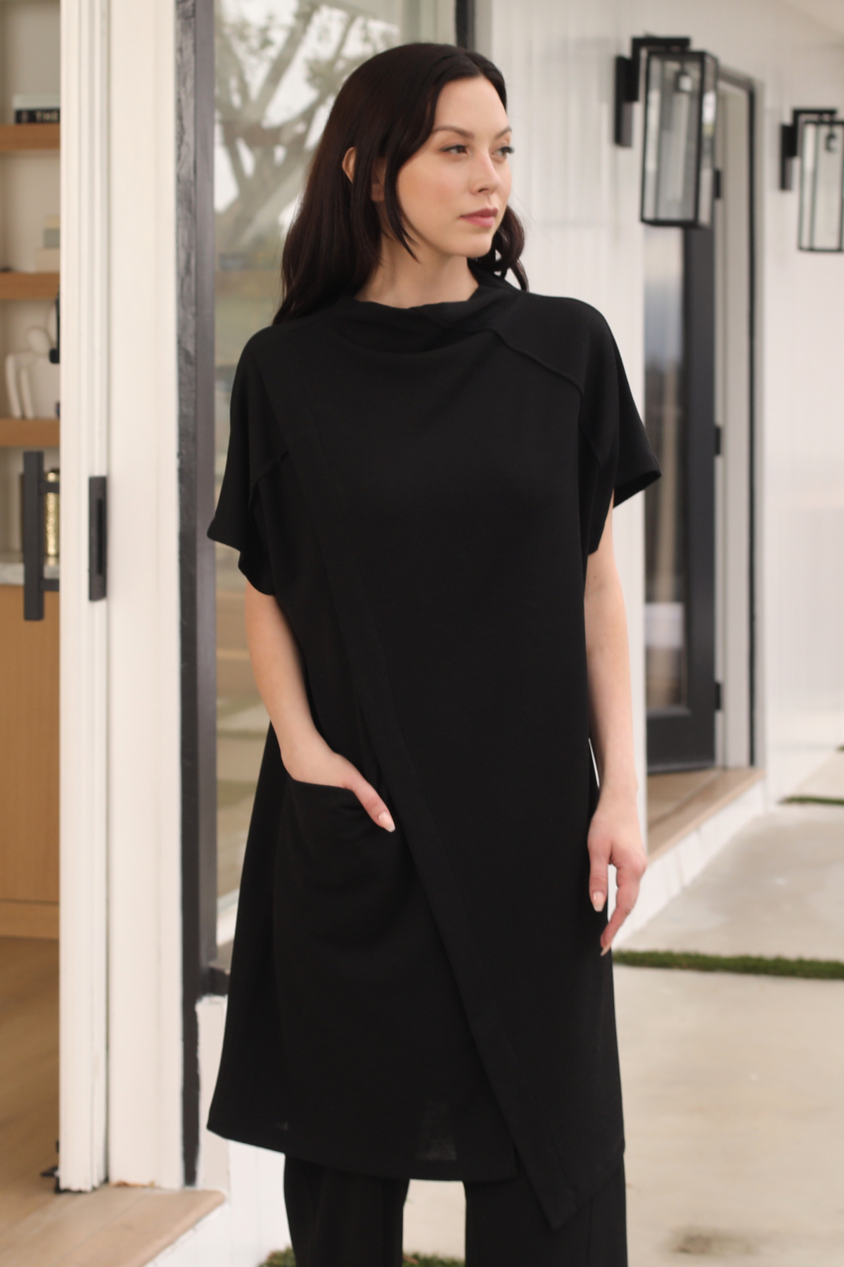 Woman wearing a black dress standing in a modern indoor setting